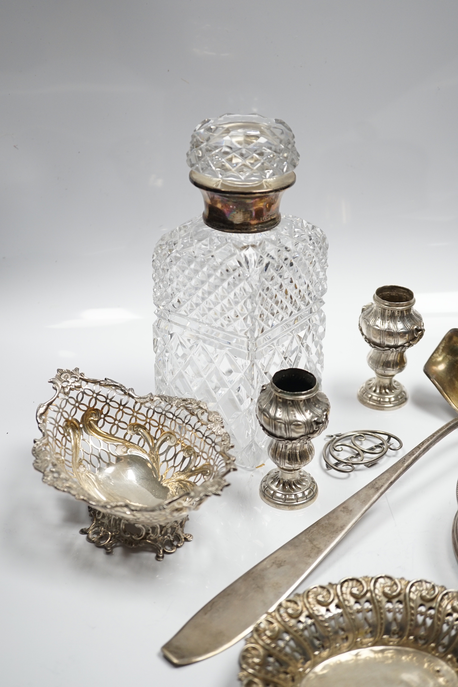 Assorted silver and white metal items including a pair of late Victorian pierced silver bonbon dishes, a pierced silver small bowl, a modern silver wine coaster, a silver belt buckle, white metal belt buckle, two contine